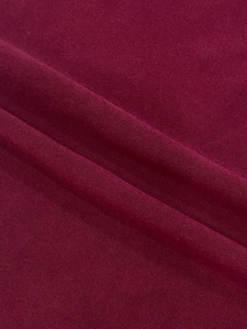 Close-up of the smooth burgundy knit fabric texture and soft drape of this dress