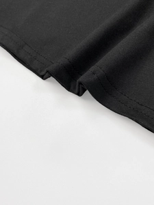 Detailed close-up showing the high-quality twin-needle stitching on the black knit dress hem