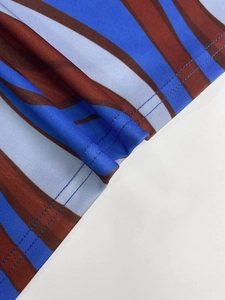 Close-up of double-needle stitching and wave print on blue and brown knit fabric