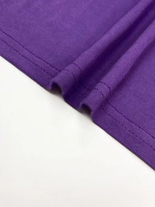 Detail of double-needle stitching on the hem of a purple pleated plus size dress