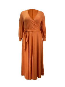 Detailed view of an orange V-neck wrap dress featuring a waist tie and long cuffed sleeves