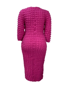 Détail de la texture gaufrée magenta sur une robe midi à manches bouffantes