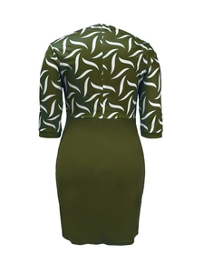 Back view of a sleek bodycon dress with dark green skirt and leaf print bodice