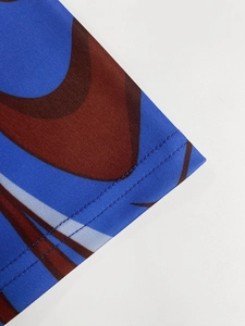 Macro detail of the blue abstract print dress showing double-needle hem and knit texture