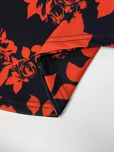 Close-up of high-density knit fabric hem with red floral print and double stitching