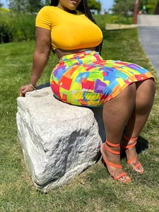 Two-piece set featuring an orange crop top and a multi-color abstract print bodycon skirt
