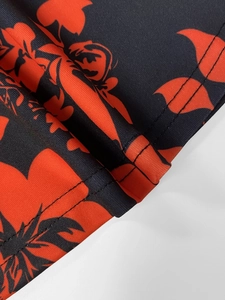 Detail of twin needle stitching on black fabric with vibrant orange floral prints