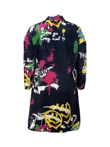 Détails des imprimés graffiti sur la robe chemise noire ample avec col à revers