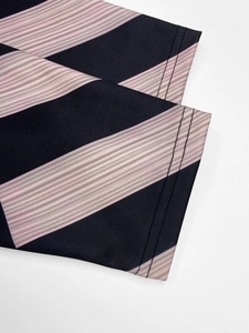 Close-up of black and pink striped fabric with fine ribbed texture and double stitching