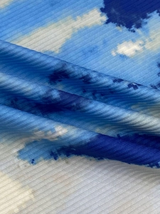 Detailed close-up of blue and white gradient ribbed knit fabric with abstract cloud pattern