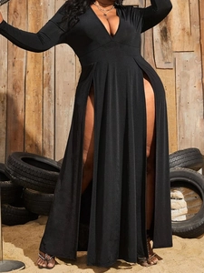 Detail view of high waist slit and glossy elastic fabric on a black V-neck maxi dress
