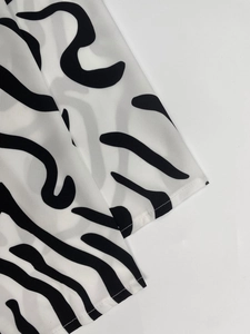 Close-up of black and white abstract wavy pattern with precise flat-lock stitching