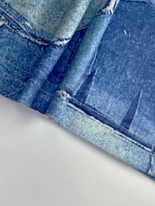 Detail of double-needle stitching on blue denim print fabric with soft texture