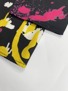 Gros plan d'imprimé taches de peinture sur tissu noir avec couture d'ourlet roulé soignée