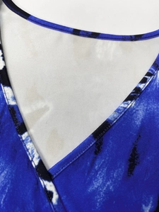 Détail de l'encolure en V avec imprimé tie-dye bleu marine et finitions de couture précises