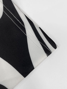Detailed close-up of double-needle stitching on zebra print knit dress fabric
