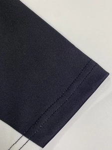 Détail de la couture à double aiguille et texture du tissu bleu marine de la robe