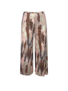 Detailed view of elastic waistband on pleated wide-leg trousers with camouflage print
