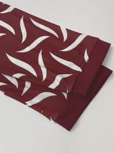 Close-up detail of burgundy dress with white wavy print showing hem stitching quality