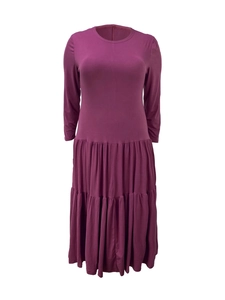 Detailed view of dark purple tiered dress featuring crew neck and long sleeves
