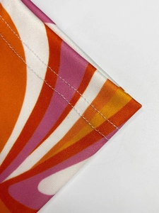 Détail de l'ourlet à double couture et imprimé vagues rétro orange rose sur la robe