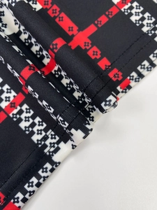Detail of red and black checkered knit dress with monogram floral pattern and flat seam