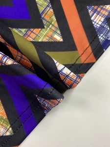 Detailed macro view of geometric printed fabric with precise overlock stitching detail