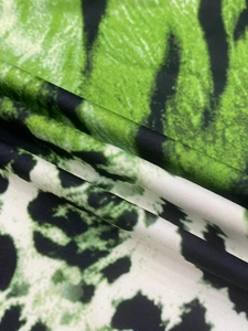 Gros plan détaillé du tissu de robe à col en V avec motif animalier vert et noir