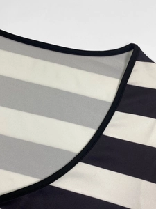 Detail of V-neckline with black trim on slim fit striped knit dress fabric