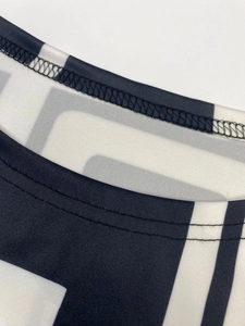 Detail of high-density knit fabric with black and white geometric pattern and double stitching