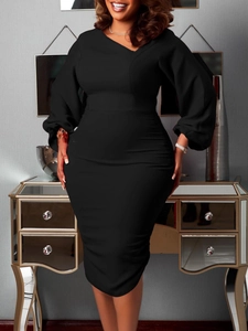 Detail of elegant black slim fit dress with asymmetric V-neck and puff long sleeves