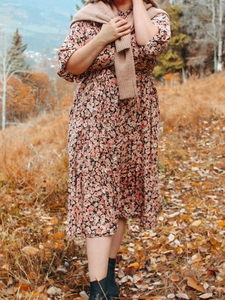 Détail d'une robe mi-longue fleurie vintage avec col en V et motifs floraux d'automne