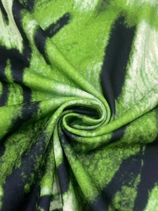 Gros plan sur l'imprimé artistique vert et noir du tissu doux de la robe en tricot