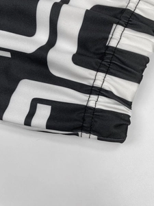 Close-up of geometric black and white print fabric with elastic hem and double stitching