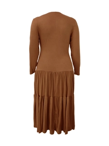 Detail of tiered skirt layers on a caramel brown round neck long sleeve dress