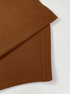 Detailed view of dark brown knitted dress featuring high-quality double-needle stitching