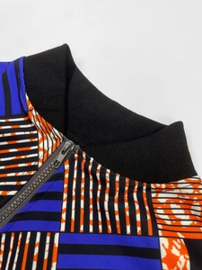 Detail of geometric print jacket featuring a black ribbed collar and grey zipper closure
