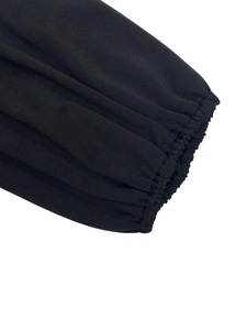 Detailed view of elastic ribbed cuffs on a black long-sleeved dress with premium knit fabric