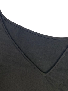Detail view of the V-neckline with double-needle stitching on the black knit dress