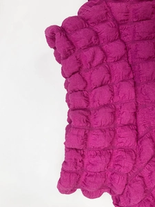 Detail of magenta bubble popcorn textured fabric showing unique shirring surface effect