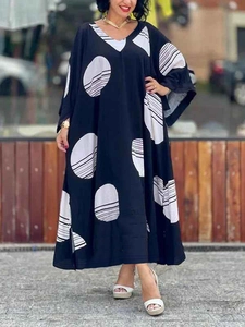 Close-up detail of V-neckline and batwing sleeves on a black polka dot maxi dress