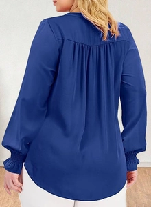 Detail view of royal blue blouse featuring pleated back design and elastic ruffled cuffs