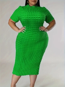 Detail showing the textured bubble popcorn fabric on a fitted green plus size dress