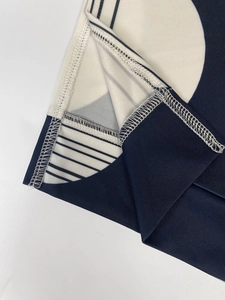 Detailed close-up showing reinforced stitching and geometric pattern on navy blue dress fabric