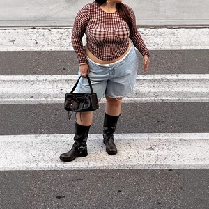 Top taglie forti da donna a scacchi con pantaloncini di jeans in un look stile street
