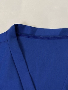 Detail shot of the V-neckline on a dark blue long sleeve shirt with premium stitching