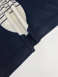 Close-up of navy blue dress with white dot print and premium double-needle stitching