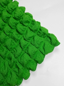 Detail of green popcorn texture fabric showing elastic bubbly pattern on dress