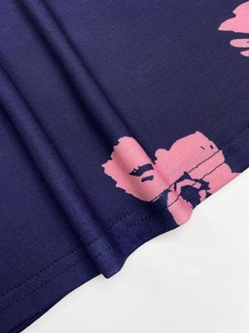 Detail of double-needle stitched hem on dark blue floral print long sleeve top