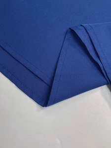 Close-up of royal blue V-neck top showing precise stitching and fabric texture